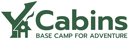 Logo for "Ya Cabins: Base Camp for Adventure," featuring a cabin and upward arrows.
